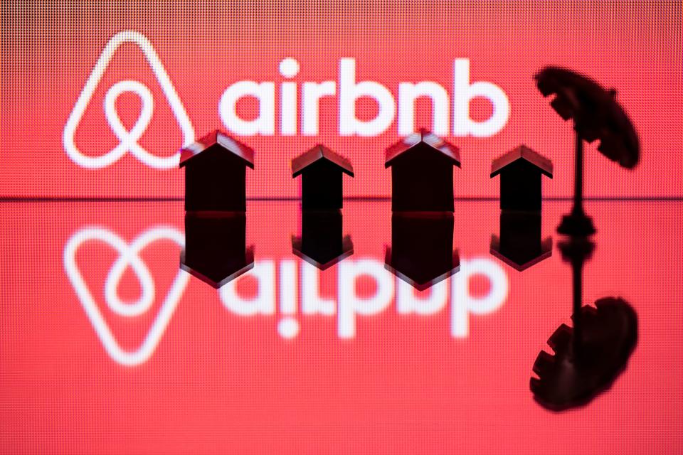 This illustration picture taken in Paris on August 29, 2018, shows  a toy umbella and houses next to the logo of  rental website Airbnb. (Photo by JOEL SAGET / AFP)        (Photo credit should read JOEL SAGET/AFP/Getty Images)