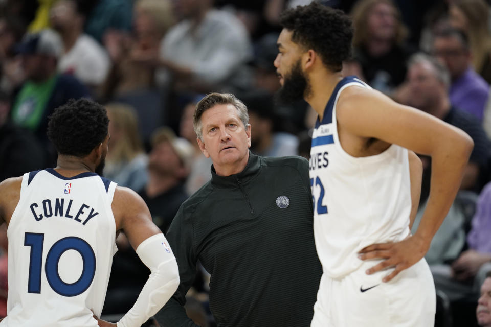 Minnesota Timberwolves head coach Chris Finch talks with Minnesota Timberwolves guard Mike Conley and Karl-Anthony Towns during the first half of an NBA basketball game, Sunday, April 9, 2023, in Minneapolis. (AP Photo/Abbie Parr)