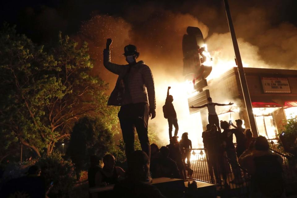 <div class="inline-image__caption"><p>People demonstrated outside a burning Arby's fast food restaurant on May 29, 2020, in Minneapolis during a protest over the death of George Floyd, a Black man who died after a white Minneapolis police officer pressed a knee into his neck for eight minutes.</p></div> <div class="inline-image__credit">John Minchillo/AP</div>