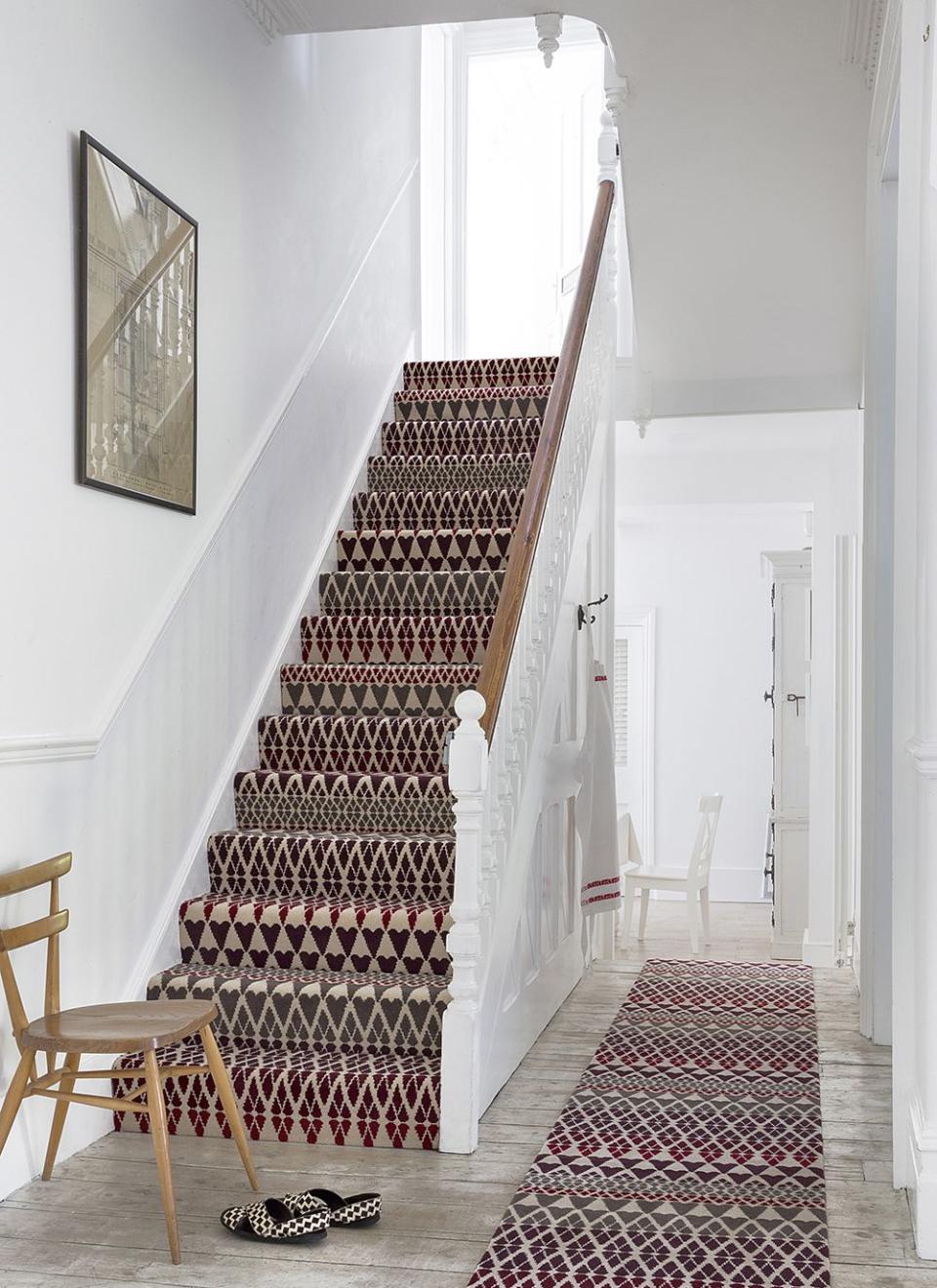 <p>Pristine white walls and light wooden floors are the perfect base for brave design choices. Here, Margo Selby's signature geometric pattern in a colourful mixture of burgundy, cream and green becomes a real feature - doubly so by matching a stair carpet with a runner. </p><p>Pictured: <a href="https://www.alternativeflooring.com/collection/quirky_b/quirky_b__margo_selby_collection/quirky_b_fair_isle/annie.html" rel="nofollow noopener" target="_blank" data-ylk="slk:Margo Selby Fair Isle Annie Carpet at Alternative Flooring;elm:context_link;itc:0;sec:content-canvas" class="link ">Margo Selby Fair Isle Annie Carpet at Alternative Flooring</a></p>