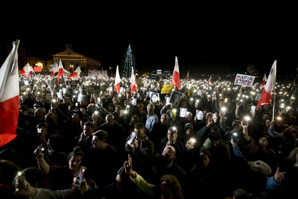 Protesters hold photos of investigative journalist Daphne Caruana Galizia, as they partecipate in a demonstration in Valletta, Malta, Friday night, Nov. 29, 2019. The family of the journalist who was killed by a car bomb in Malta is urging Maltese Prime Minister Joseph Muscat to resign, after his former chief aide was released from jail in a probe aimed at finding the mastermind of the 2017 murder. (AP Photo/Rene' Rossignaud)