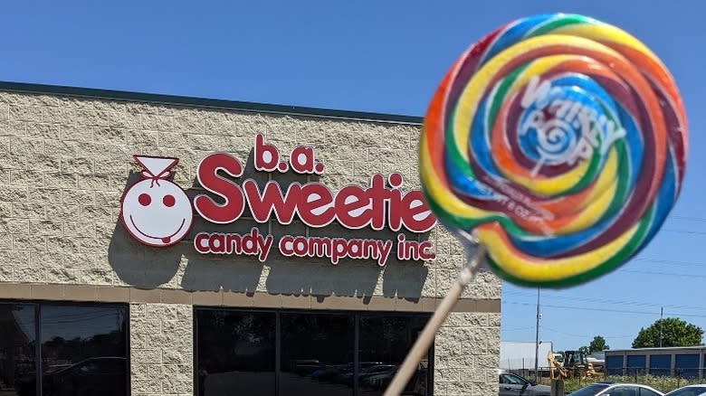 Whirley pop held in front of b.a. Sweetie Candy Co. storefront