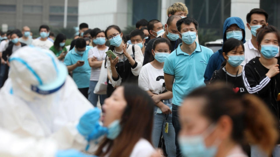 A crowd of people in China are seen wearing masks to protect from coronavirus.