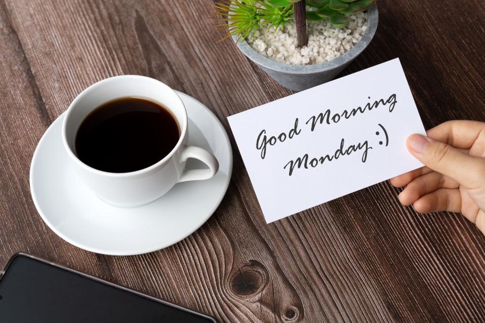hand holding a piece of paper with good morning monday greeting