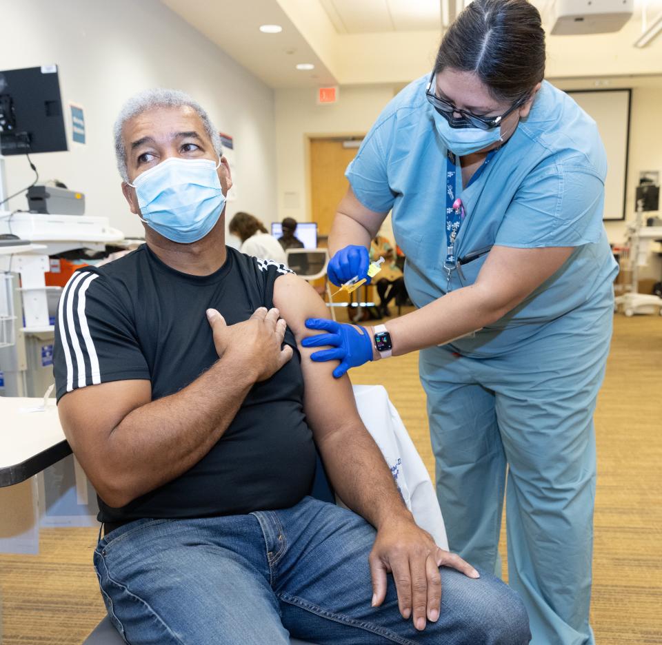 Dr. Brian Thompson, an emergency room physician at Kaiser Permanente in Los Angeles gets his second COVID-19 shot. Thompson was one of the first on the West Coast to be immunized with the new vaccine on Dec. 14, 2020.