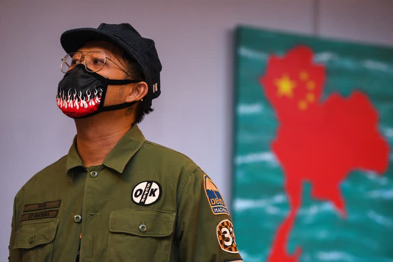 Headache Stencil, a graffiti artist poses in front of his works during his exhibition at The Foreign Correspondents' Club of Thailand (FCCT) in Bangkok