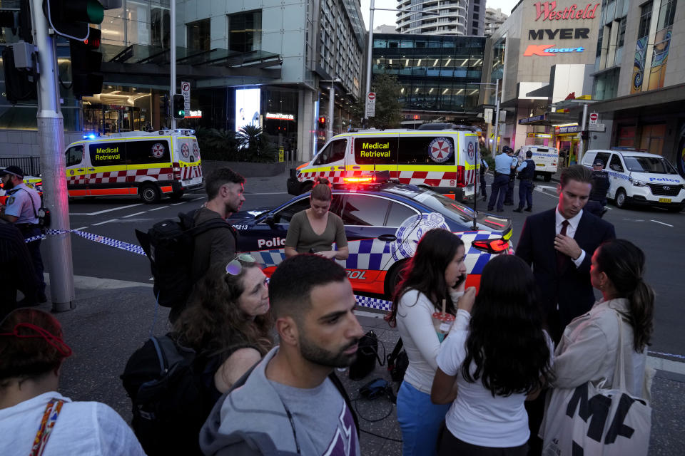 A crowd gathers outside Westfield Shopping Centre in Sydney, Saturday, April 13, 2024. Media reports say multiple people have been stabbed and that the police shot a person at the Sydney shopping center. (AP Photo/Rick Rycroft)