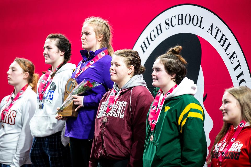 Nevada's Mackenzie Arends, third from left, poses for a photo atop the podium after her match at 190 pounds in the finals during the IGHSAU state girls wrestling tournament.