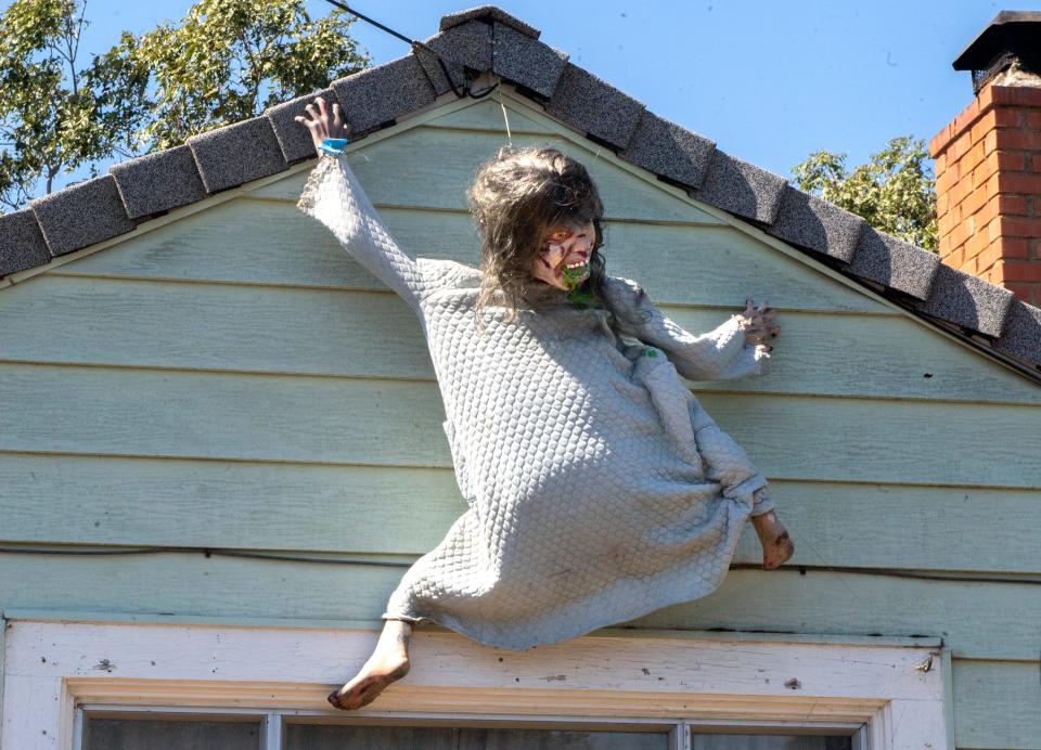 A Linda Blair figure from the Exorcist climbs the side of Jeanna Pack's home on Oto Avenue near Farm Street in east Stockton on Thursday, Sept. 22, 2022. Pack has been doing elaborate Halloween displays at her home for the past 26 years. CLIFFORD OTO/THE STOCKTON RECORD