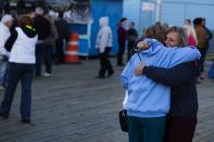 Women seeing each other for the first time in a year greet while taking part in a "Light The Shore" event on the one year anniversary of the landfall of Hurricane Sandy in Seaside Heights, New Jersey October 29, 2013. A year after Superstorm Sandy inundated the East Coast with record flooding that left 159 people dead, residents of hard-hit New Jersey and New York shore communities still have a ways to go in rebuilding damaged homes. REUTERS/Lucas Jackson (UNITED STATES - Tags: DISASTER ENVIRONMENT ANNIVERSARY)