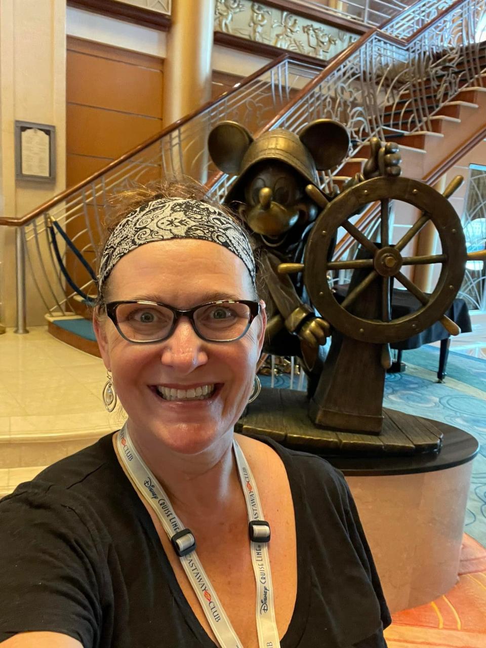 the writer on the disney magic posing with a bronze statue