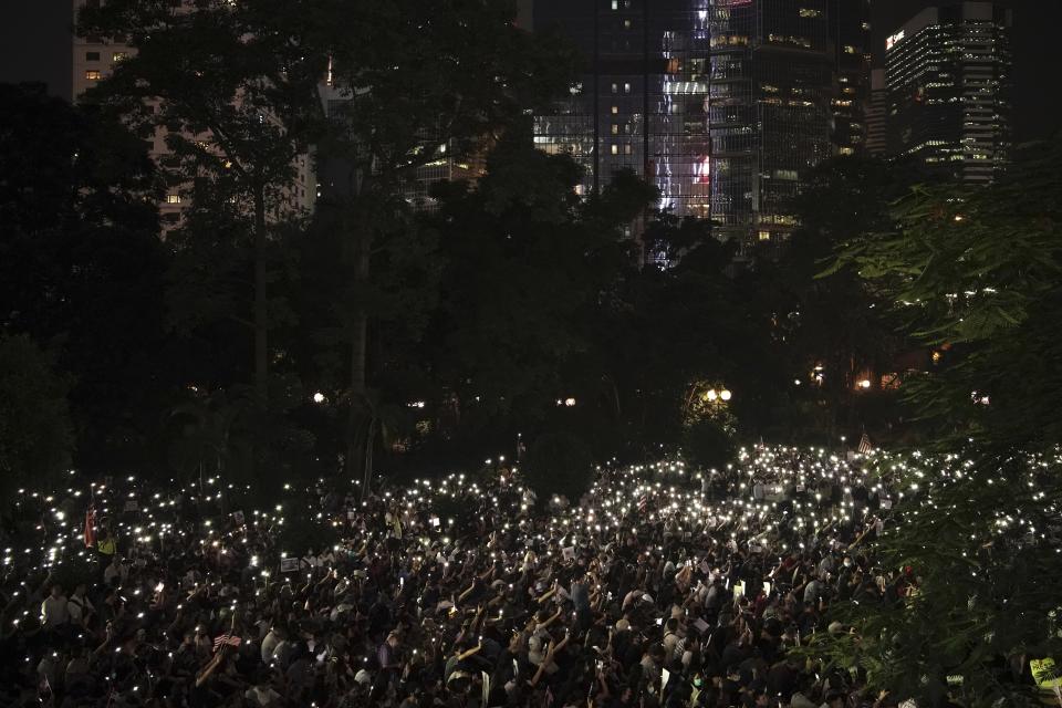 Protestors light their torches during a peaceful rally in central Hong Kong's business district, Monday, Oct. 14, 2019. The protests that started in June over a now-shelved extradition bill have since snowballed into an anti-China campaign amid anger over what many view as Beijing's interference in Hong Kong's autonomy that was granted when the former British colony returned to Chinese rule in 1997. (AP Photo/Felipe Dana)