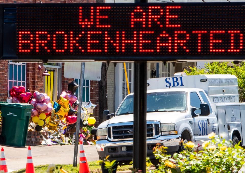 A sign in front of Dadeville City Hall reads “We Are Brokenhearted” with the makeshift memorial at the fatal  shooting scene in the background in Dadeville, Ala., on Wednesday April 19, 2023. 