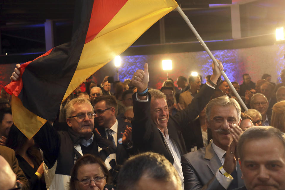 Supporters of the nationalist Alternative for Germany AfD celebrate after the state election in the German state of Hesse in Wiesbaden, western Germany, Sunday, Oct. 28, 2018. Exit polls show Chancellor Angela Merkel’s party leading with a significant drop in support for both her conservatives and their center-left partners in the national government. (Frank Rumpenhorst/dpa via AP)