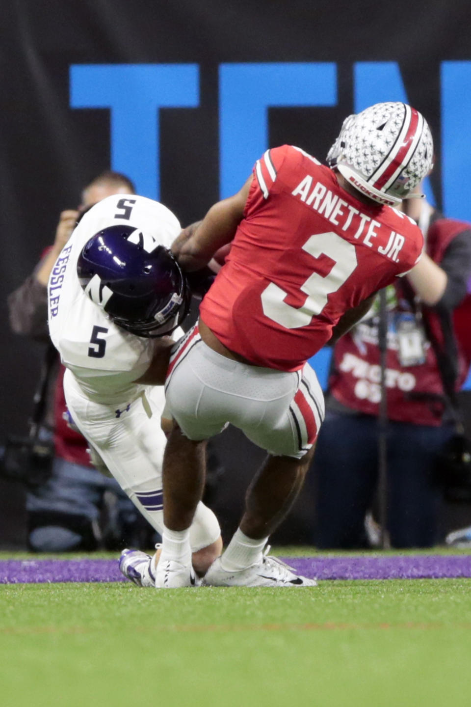Northwestern wide receiver Charlie Fessler (5) begins to fumble as he is tackled by Ohio State cornerback Damon Arnette (3) during the second half of the Big Ten championship NCAA college football game, Saturday, Dec. 1, 2018, in Indianapolis. After review, Fessler was ruled down before the fumble and Northwestern maintained in position of the ball. (AP Photo/AJ Mast)