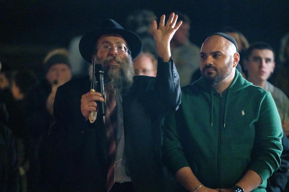 Rabbi Yossi Jacobson speaks to the crowd during the first night of Hanukkah celebration on Thursday outisde Maccabee's Deli in Des Moines.