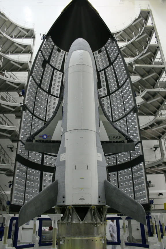 Photo of the first X-37B Orbital Test Vehicle waits in the encapsulation cell of the Evolved Expendable Launch vehicle April 5, 2010, at the Astrotech facility in Titusville, Fla. Half of the Atlas V five-meter fairing is visible in the backgro