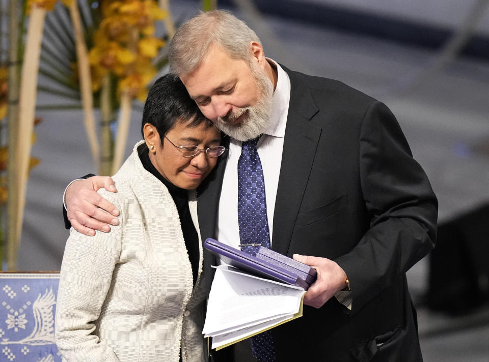 FILE - Nobel Peace Prize winners Dmitry Muratov from Russia, right, and Maria Ressa of the Philippines embrace during the Nobel Peace Prize ceremony at Oslo City Hall, Norway, Friday, Dec. 10, 2021. For the two journalists who won the Nobel Peace Prize in 2021, the past year has not been easy. Dmitry Muratov of Russia and Maria Ressa of the Philippines have been fighting for the survival of their news organizations, defying government efforts to silence them. (AP Photo/Alexander Zemlianichenko, File)