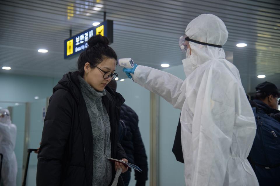 A woman has her temperature taken at Pyongyang International Airport. 