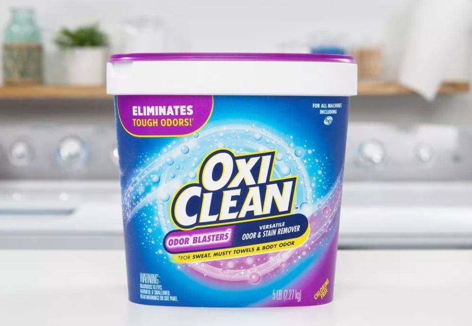 Container of OxiClean detergent on countertop advertising stain and odor removal
