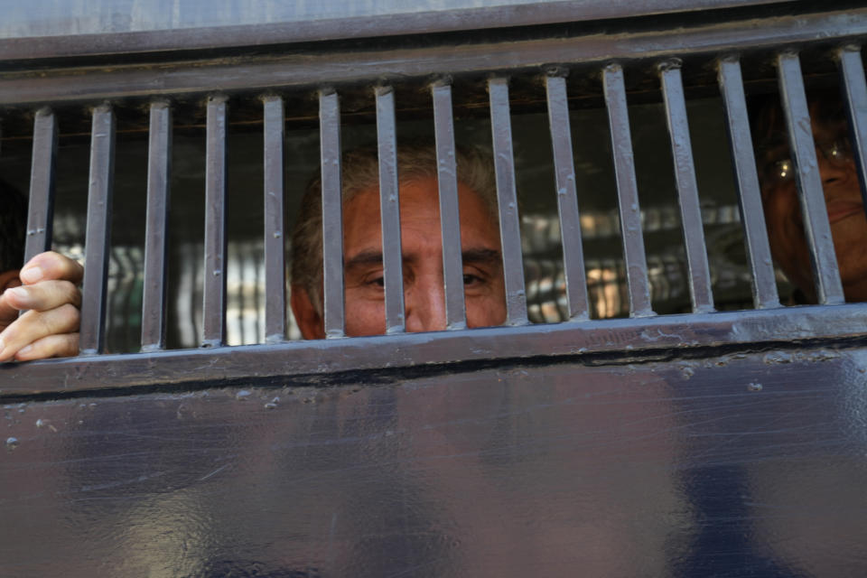 Shah Mahmood Qureshi, left, and Asad Omar, senior leaders of Pakistan's former prime minister Imran Khan's 'Pakistan Tehreek-e-Insaf' party look to media from inside a police van during a rally, in Lahore, Pakistan, Wednesday, Feb. 22, 2023. Hundreds of supporters of Pakistan's former prime minister on Wednesday defied a ban on rallies in a commercial area of the city of Lahore, taunting police and asking to be arrested en masse. (AP Photo/K.M. Chaudary)