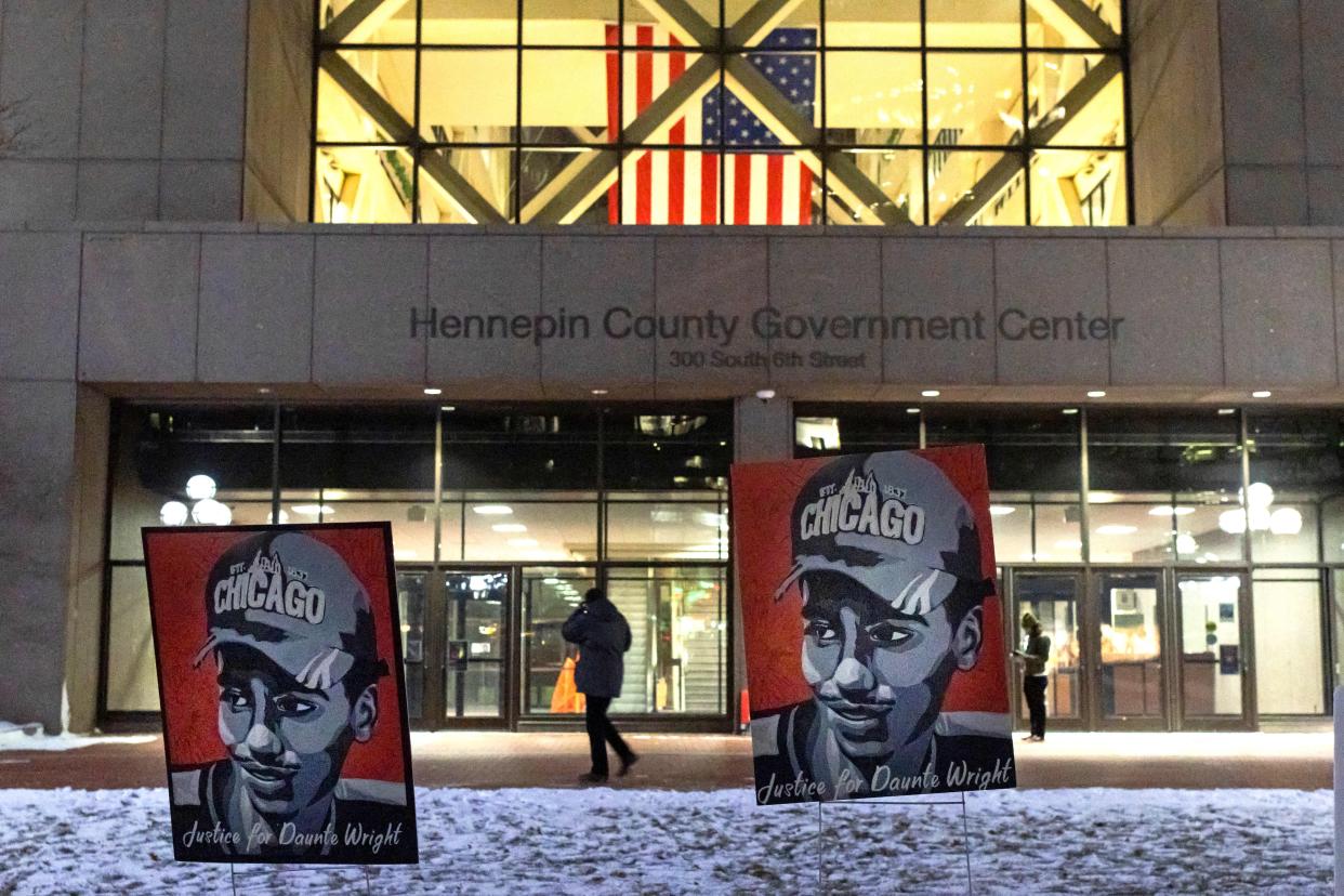 Two large illustrations of Daunte Wright are seen outside the Hennepin County courthouse in Minneapolis. The posters read: Justice for Daunte Wright.