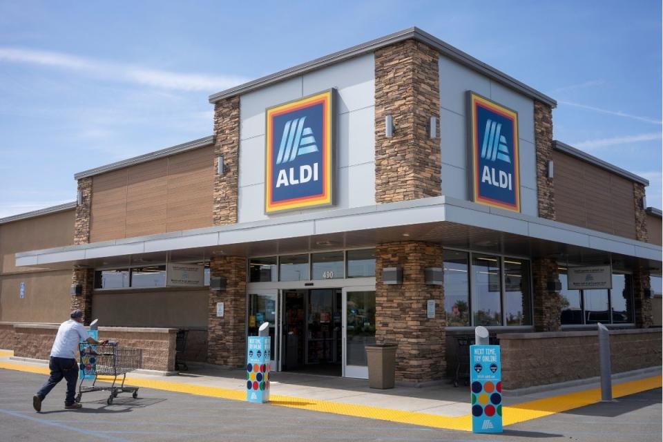 Aldi shopper pushes trolley inside open supermarket