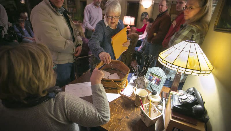 Sharon McNutt hands the ballots to an official to be counted at a caucus site on Monday, Feb 1, 2016, in Silver City, Iowa.