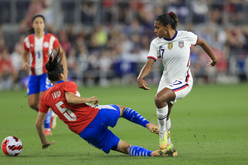 United States midfielder Catarina Macario, right, passes the ball against Paraguay defender Tania Riso (5) during the first half of an international friendly soccer match, Tuesday, Sept. 21, 2021, in Cincinnati. (AP Photo/Aaron Doster)