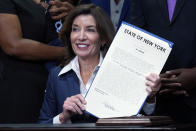 New York Gov. Kathy Hochul holds the "Less is More" law she signed, during ceremonies in the her office, in New York, Friday, Sept. 17, 2021. New Yorkers will be able to avoid jail time for most nonviolent parole violations under a new law that will take effect in March, and largely eliminates New York's practice of incarcerating people for technical parole violations. (AP Photo/Richard Drew)