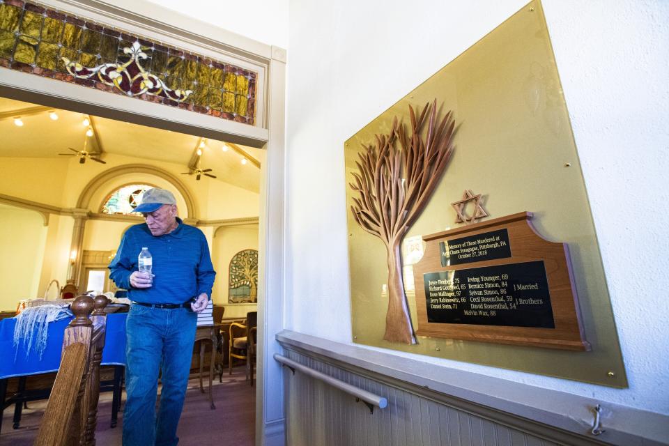 FILE - In this Nov. 5, 2019, file photo, Temple president Michael Atlas-Acuña walks past a memorial inside the historic Temple Emanuel in Pueblo, Colo., for the victims of the 2018 Aytz Chaim Synagogue shooting in Pittsburg, Pa.Richard Holzer, 28, a man described by federal prosecutors as a neo-Nazi and white supremacist, pleaded guilty Thursday, Oct. 15, 2020, to a hate crime for plotting to bomb the historic Colorado synagogue last year. (Christian Murdock/The Gazette via AP, File)