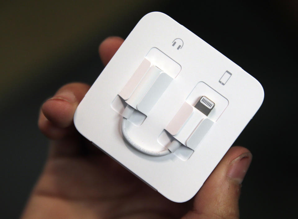 FILE - A customer holds a Lightning to 3.5mm headphone jack adapter cable at the Apple Store on Michigan Avenue, Friday, Sept. 16, 2016, in Chicago. Apple is ditching its in-house iPhone charging plug and falling in line with the rest of the tech industry by adopting USB-C, a more widely used connection standard. (AP Photo/Kiichiro Sato, File)