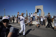 French torchbearer Tony Parker waves as he participates in the first stage of the Olympic torch relay in Marseille, southern France, Thursday, May 9, 2024. Torchbearers are to carry the Olympic flame through the streets of France' s southern port city of Marseille, one day after it arrived on a majestic three-mast ship for the welcoming ceremony. (AP Photo/Thibault Camus)