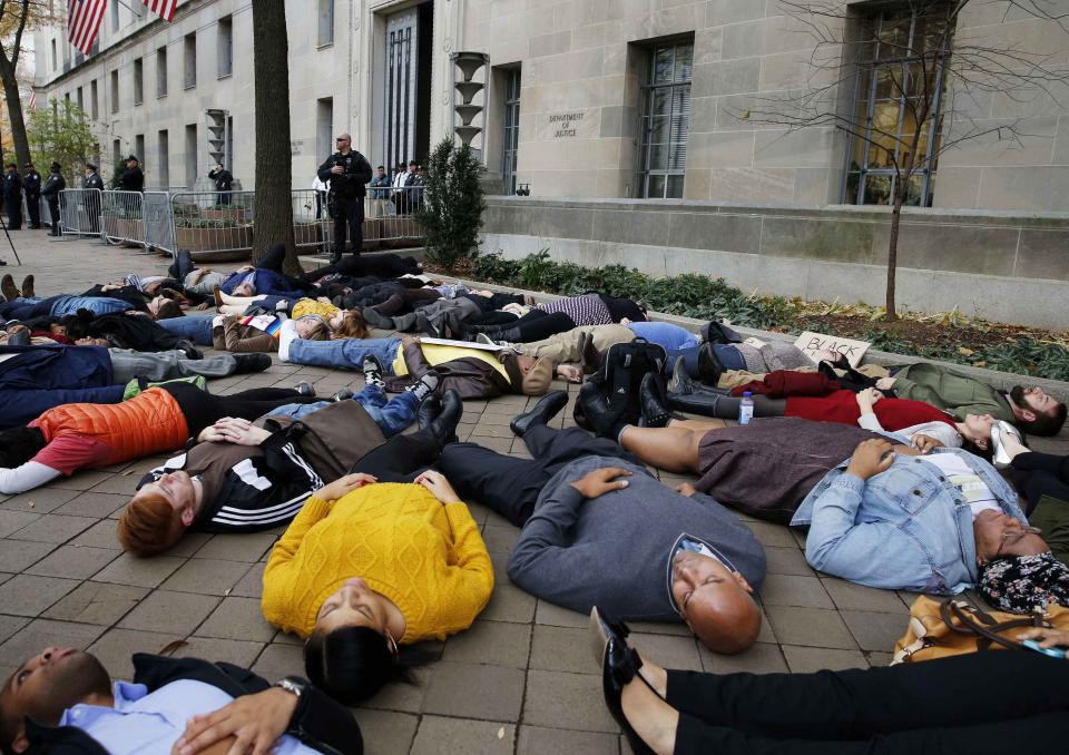 Protestors stage a "die-in" as they rally against the Ferguson, Mo. Grand Jury exoneration of police officer Darren Wilson for his August 2014 shooting and killing of Michael Brown while, at the U.S. Justice Department in Washington, December 1, 2014. U.S. President Barack Obama asked Congress on Monday for $263 million for the federal response to the civil rights upheaval in Ferguson, Missouri, and is setting up a task force to study how to improve modern-day policing. REUTERS/Larry Downing (UNITED STATES - Tags: POLITICS CIVIL UNREST CRIME LAW SOCIETY)