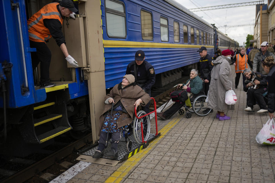 People fleeing from heavy shelling board an evacuation train at Pokrovsk train station, in Pokrovsk, eastern Ukraine, Sunday, May 22, 2022. Civilians fleeing areas near the eastern front in the war in Ukraine Sunday described scenes of devastation as their towns and villages came under sustained attack from Russian forces. (AP Photo/Francisco Seco)