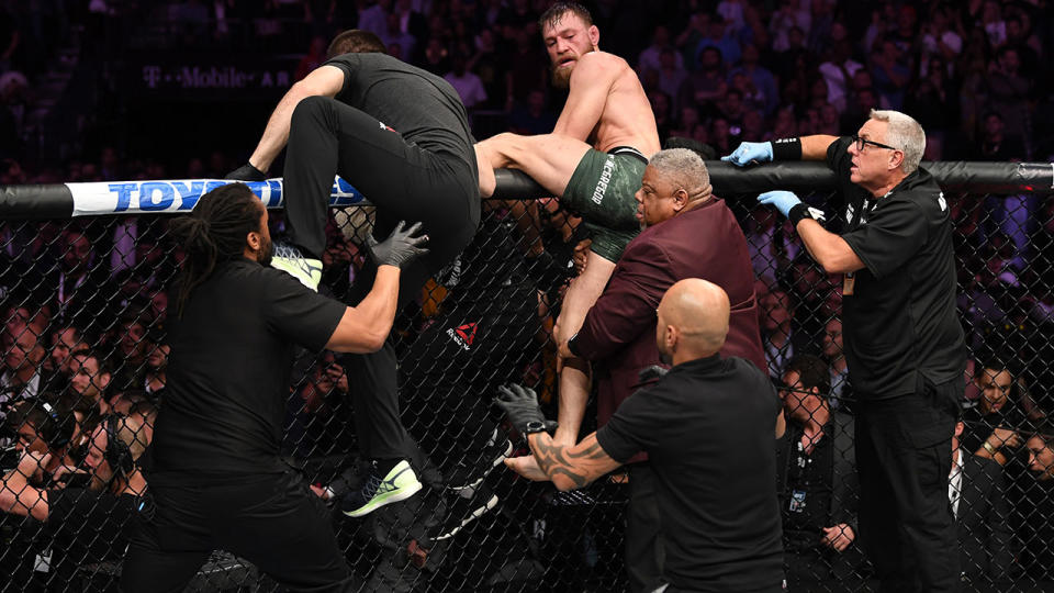 Conor McGregor attempts to leave the octagon in chase of Khabib Nurmagomedov. (Photo by Josh Hedges/Zuffa LLC/Zuffa LLC