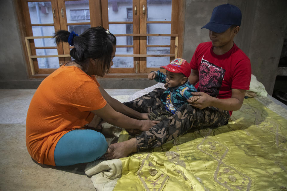 A police officer and his wife who fled Myanmar following a military coup attend to their infant at an undisclosed place in Mizoram, a state bordering Myanmar, India, Friday, March 19, 2021. Several Myanmar police officers who fled to India after defying army orders to shoot opponents of last month’s coup in their country are urging Prime Minister Narendra Modi’s government to not repatriate them and provide them political asylum on humanitarian grounds. (AP Photo/Anupam Nath)