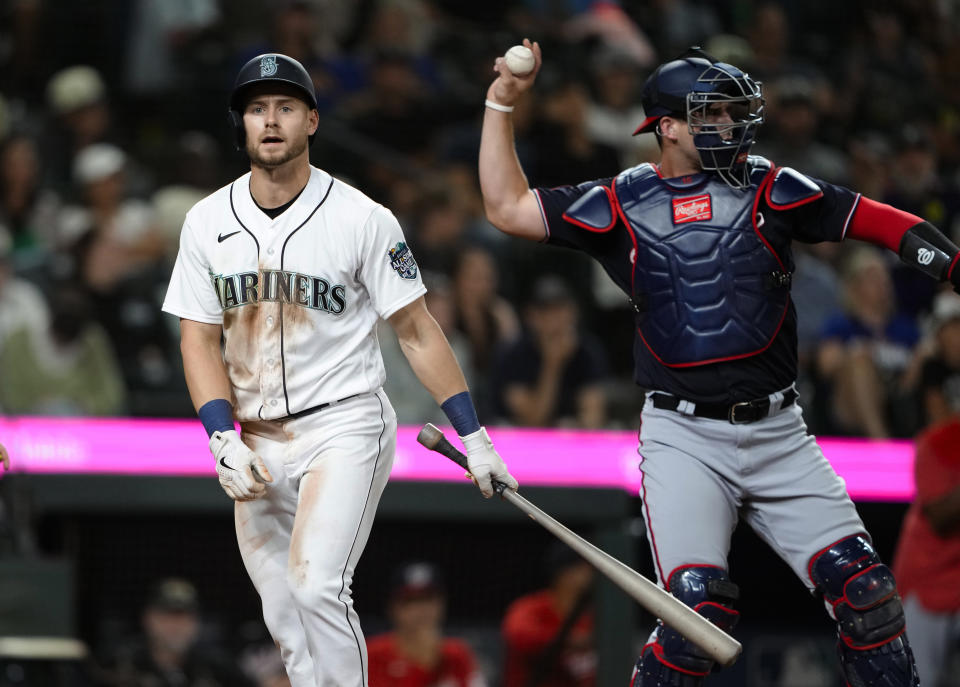 Seattle Mariners' Jarred Kelenic walks away after striking out, while Washington Nationals catcher Riley Adams throws the ball back during the 11th inning of a baseball game Tuesday, June 27, 2023, in Seattle. The Nationals won 7-4. (AP Photo/Lindsey Wasson)