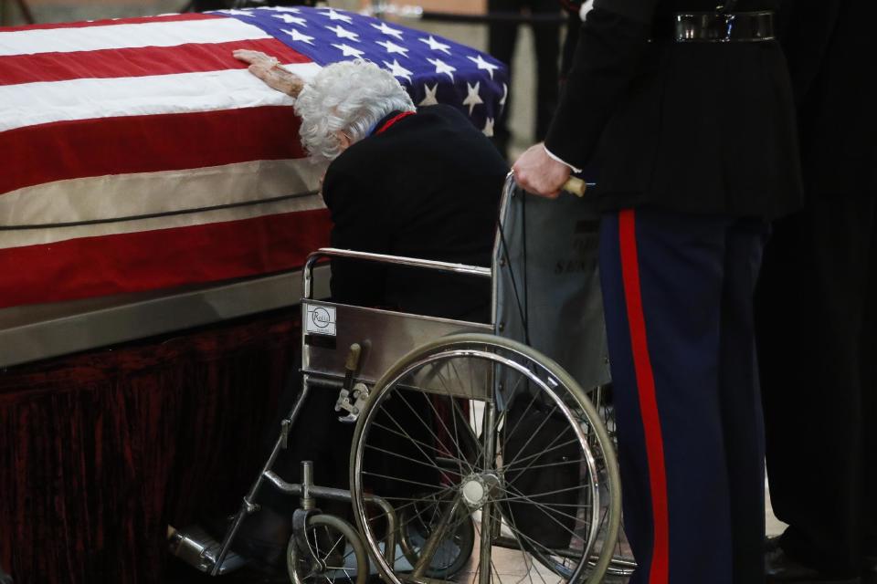 Annie Glenn rests her hand on her husband John Glenn's casket as he lies in honor, Friday, Dec. 16, 2016, in Columbus, Ohio. Glenn's home state and the nation began saying goodbye to the famed astronaut who died last week at the age of 95. (AP Photo/John Minchillo)