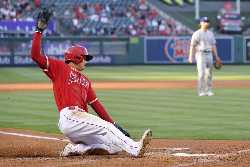 Los Angeles Angels' Shohei Ohtani, right, scores on a single by Anthony Rendon during the first inning of a baseball game against the Texas Rangers Wednesday, May 25, 2022, in Anaheim, Calif. (AP Photo/Mark J. Terrill)