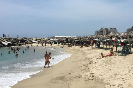 People enjoy a day on the beach in La Guaira, Venezuela May 17, 2018. REUTERS/Luc Cohen