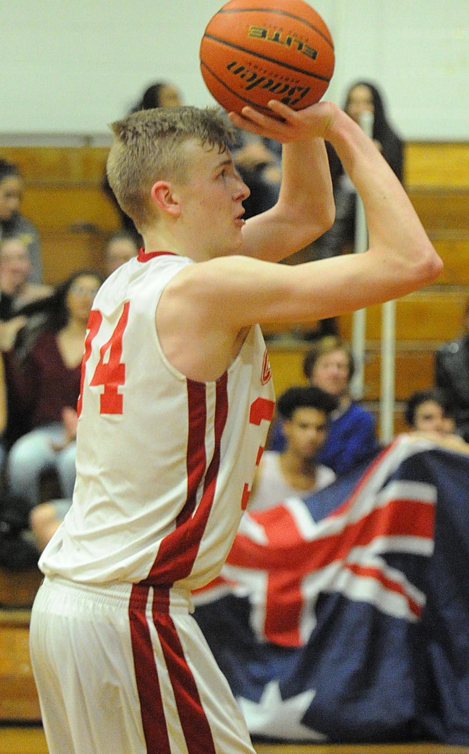In this file photo, Bishop Connolly's Cooper Creek shoots a free throw during a game against Westport, with his fan club holding the Australian flag in the bleachers.