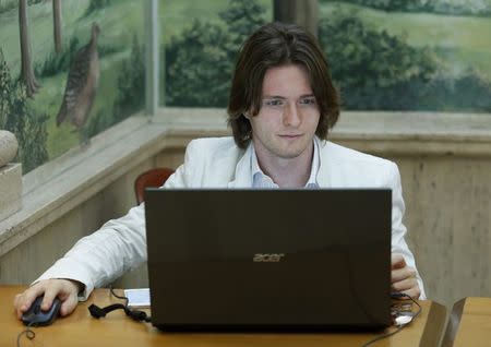 Raffaele Sollecito works at his computer before a news conference in Rome July 1, 2014. REUTERS/Remo Casilli