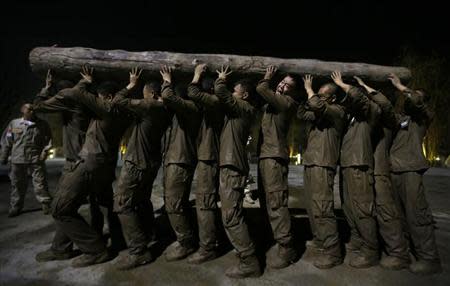 Students carry a tree trunk over their heads during high intensity training at Tianjiao Special Guard/Security Consultant camp on the outskirts of Beijing December 1, 2013. REUTERS/Jason Lee/Files