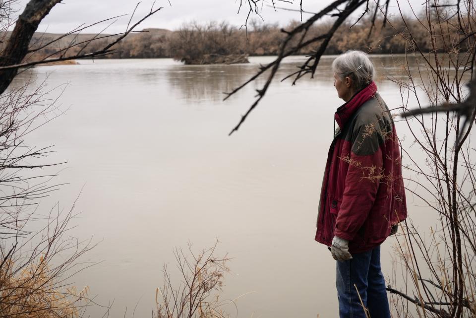 Gayna Salinas looks out over the Green River, a tributary of the Colorado River, Thursday, Jan. 25, 2024, in Green River, Utah. An Australian company and its U.S. subsidiaries are eyeing a nearby area to extract lithium, metal used in electric vehicle batteries. Salinas, whose family farms in the rural community, said she was skeptical about the project's benefits. (AP Photo/Brittany Peterson)