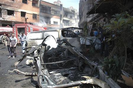 People gather at the site of two car bomb attacks at al-Abassia roundabout in Homs April 29, 2014, in this handout released by Syria's national news agency SANA. REUTERS/SANA/Handout via Reuters