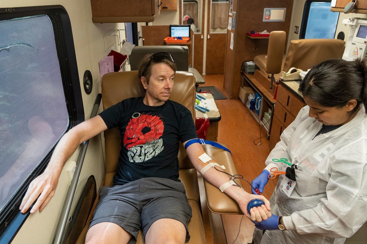 Andrew Wade donates blood with the help of phlebotomist Kassandra Godina for We Are Blood's Battle of the Badges outside the Austin Fire Department on Ed Bluestein Boulevard in June. Changes to the blood donor rules will lift some of the previous blocks on donors in the LGBTQ community.