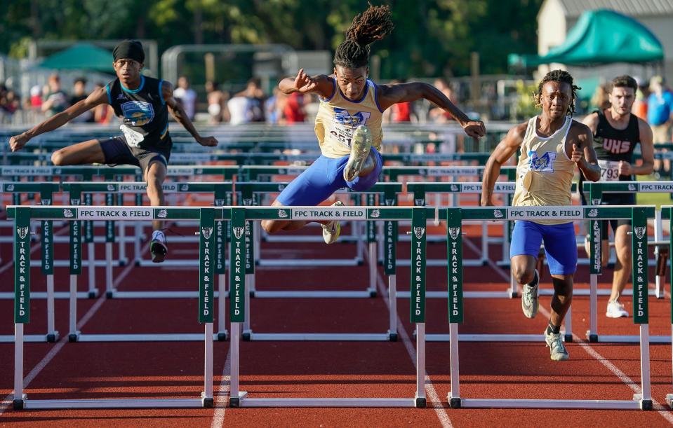 Mainland's Emmanuel Yisrael (center) races to with the Boys 110 Hurdles event at the Five Star Conference Track and Field event at Flagler Palm Coast High School, Thursday, April 4, 2024.