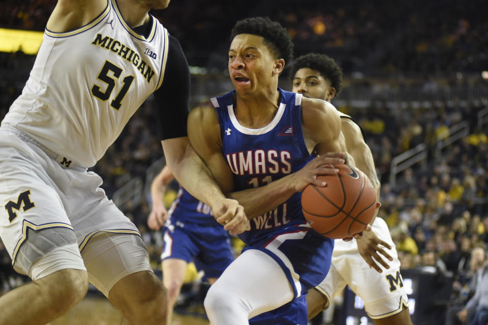 UMass-Lowell guard Obadiah Noel, right, goes to the basket as he is guarded by Michigan forward Austin Davis during the first half of an NCAA college basketball game, Sunday, Dec. 29, 2019, in Ann Arbor, Mich. (AP Photo/Jose Juarez)