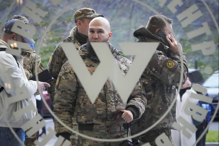 ARCHIVO - Visitantes vestidos con ropa de camuflaje militar en la entrada del "Centro Wagner PMC", vinculado al empresario y fundador del grupo militar privado Wagner, Yevgeny Prigozhin, durante la apertura del bloque de oficinas durante el Día de la Unidad Nacional, en San Petersburgo, Rusia, el viernes 4 de noviembre de 2022. (AP Foto, Archivo)